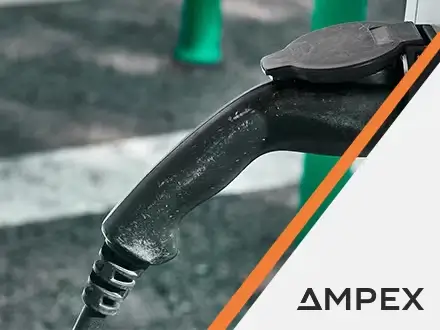 Close-up of an electric vehicle charging connector plugged into a station, with text overlay reading ‘Motion Applied launches AMPEX Ultra-Rapid EV Charging solutions to transform UK infrastructure.’ AMPEX logo appears in the bottom right corner.