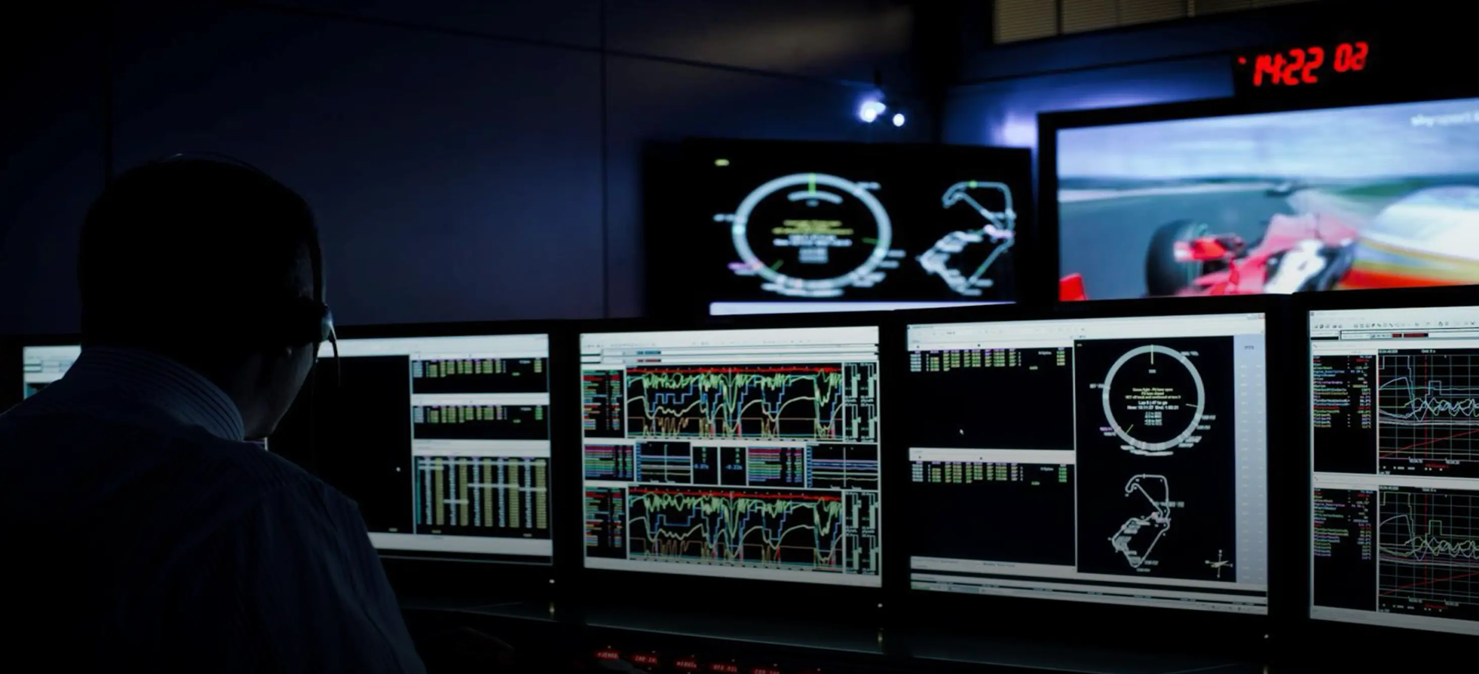 Side view of an orange and black new generation Formula 1 car with branded graphics, shown against a dark studio background.