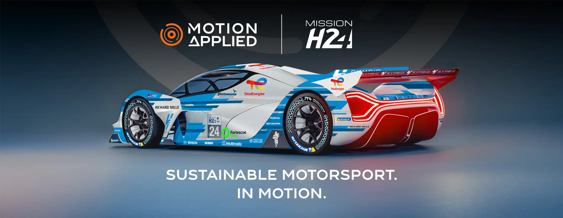 Side‑rear view of a futuristic endurance race car with blue, white, and red livery, aerodynamic bodywork, large rear wing, and sponsor logos, displayed in a studio setting on a neutral background.